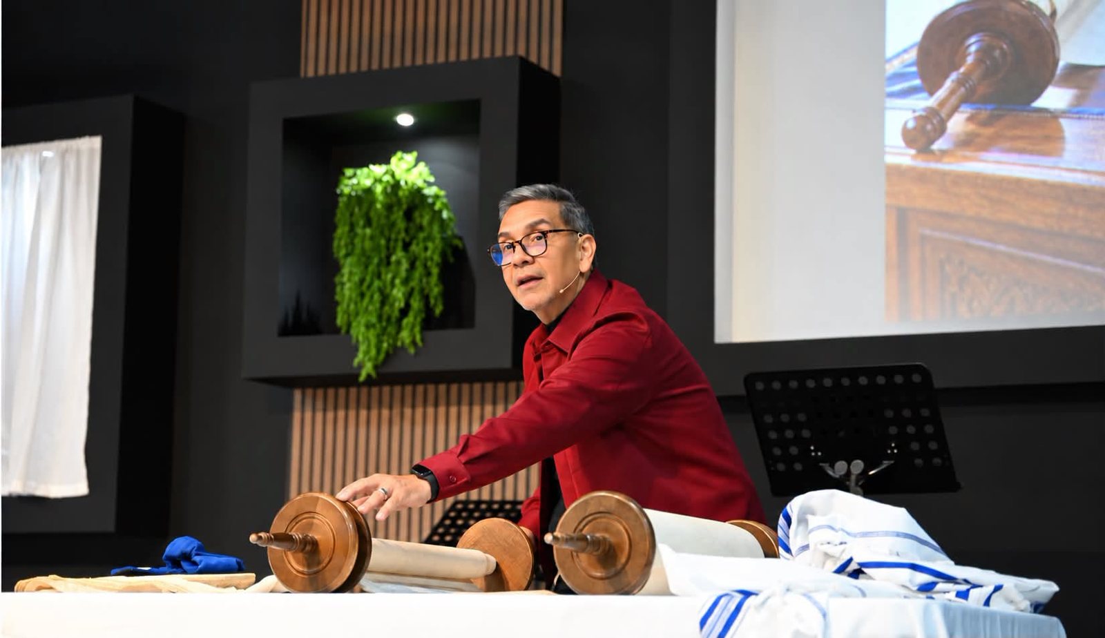 Pastor Walter Agosto enseñando con los rollos de la Torá